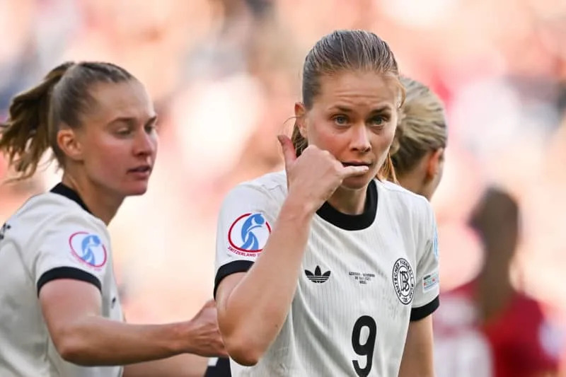 Germany's Sjoeke Nuesken (R) celebrates scoring her side's first goal during the UEFA Women's Euro 2025 Group C soccer match between Germany and Denmark at St. Jakob-Park. Sebastian Christoph Gollnow/dpa