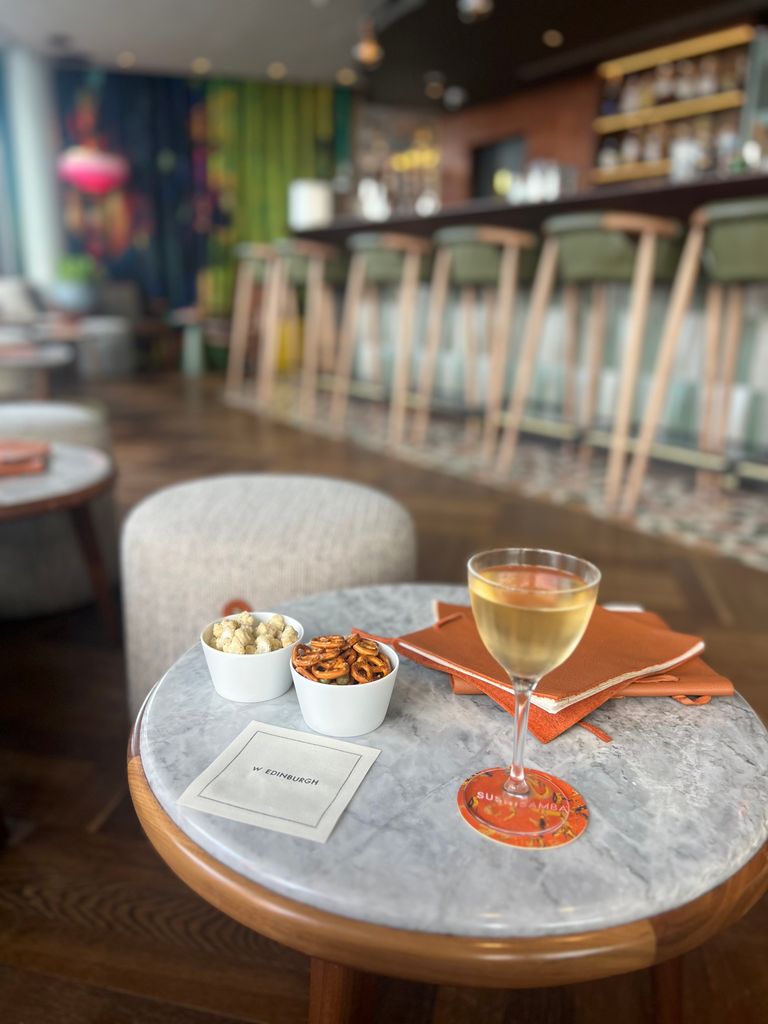 cocktail with snacks on small round table