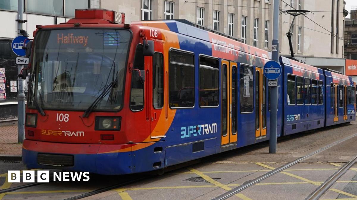 A blue and red tram. The doors are closed and the electronic sign at the front reads, 'Halfway'.