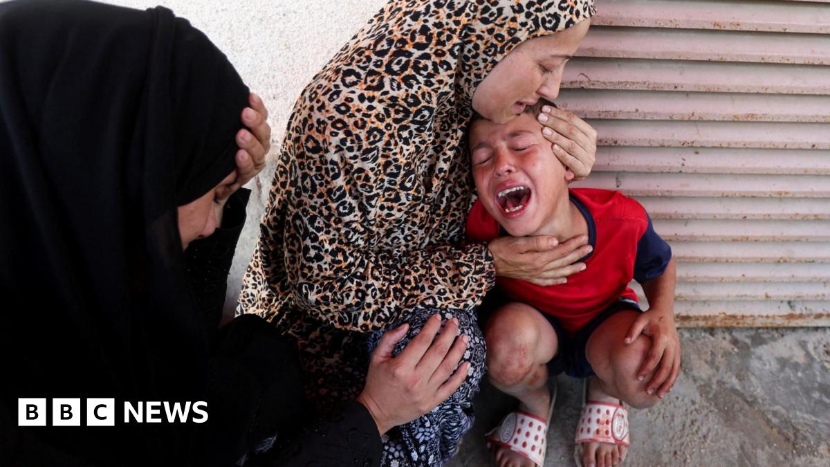 A woman comforts a child at al-Aqsa Hospital in Deir al-Balah, after medics said at least 15 people were killed in an Israeli strike at a roundabout, in central Gaza (10 July 2025)