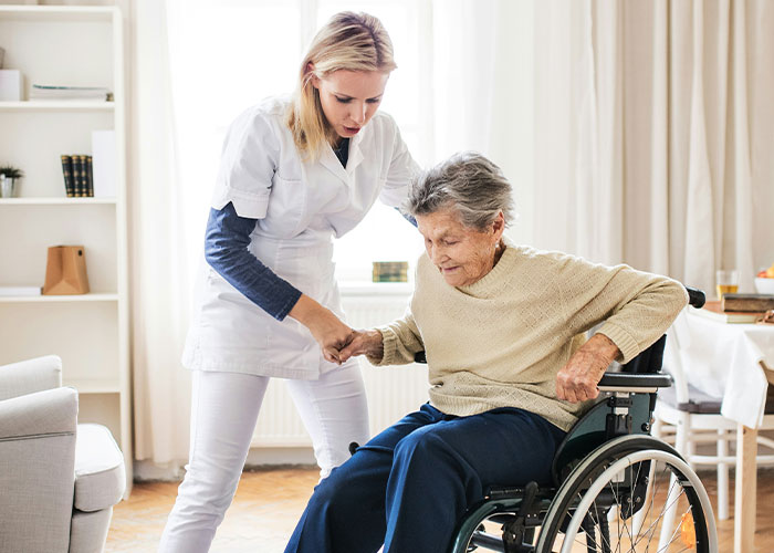 Nurse assisting elderly woman in wheelchair at home, highlighting patients delaying help and their shocking consequences.