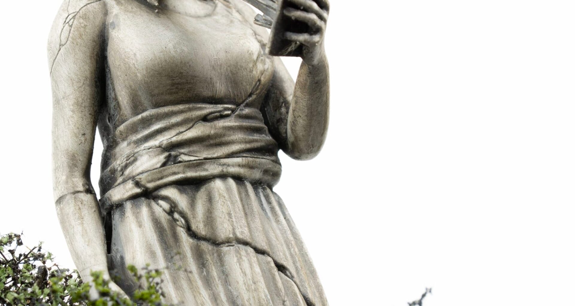 a miniature person looking at a figurative statue whose face melds into a phone
