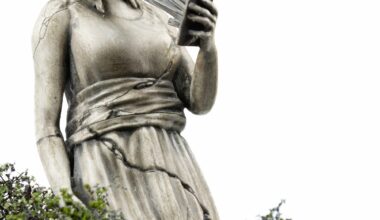 a miniature person looking at a figurative statue whose face melds into a phone