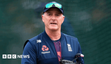An image of former England and Surrey cricketer Graham Thorpe. He is wearing a new balance gilet with England and Natwest emblems. He is wearing a cap and sunglasses.