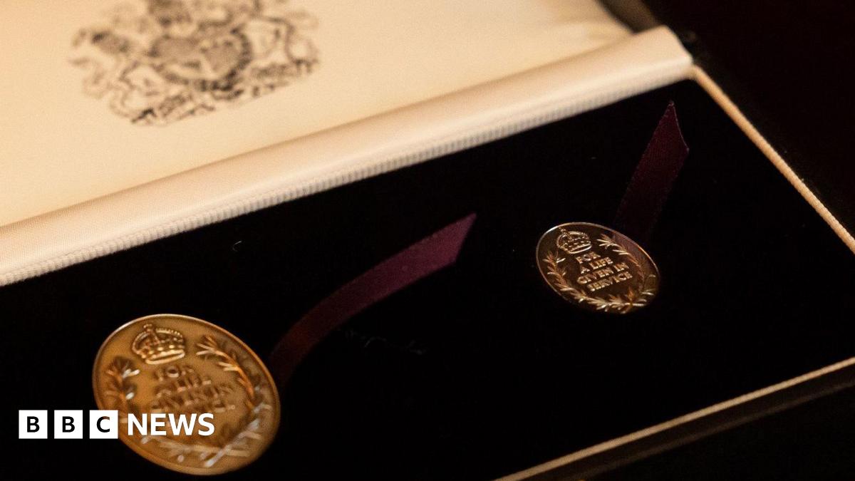 The picture shows two medals with the words for a life given in service in a case with a purple ribbon