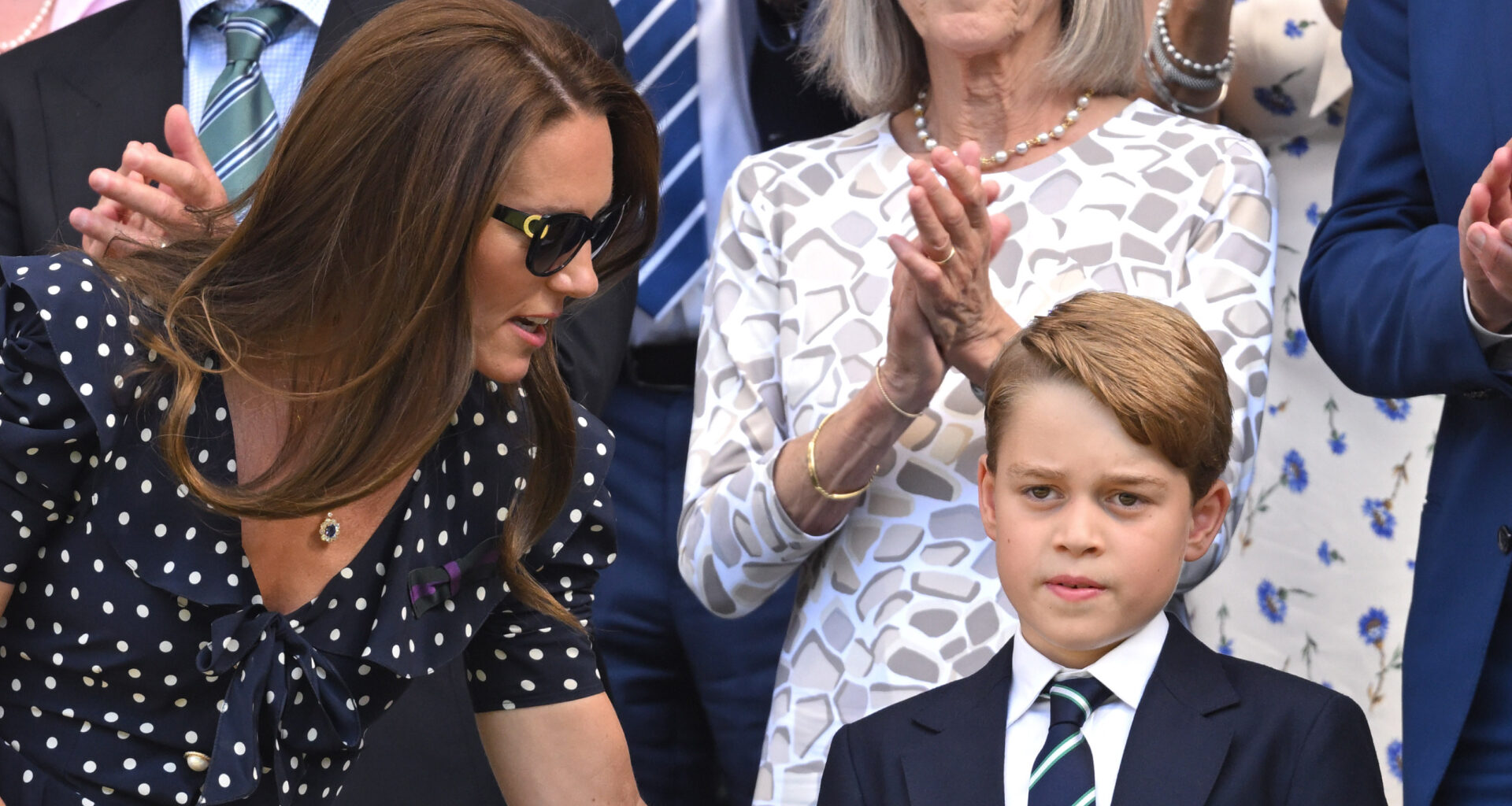 Kate Middleton wears a polka dot dress and sunglasses and talks to son Prince George who wears a navy suit with a striped tie
