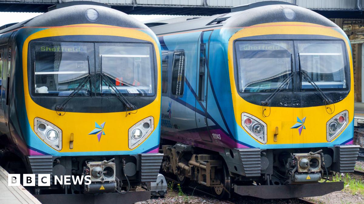 Two brightly coloured trains stand side by side on some tracks. The destination of both, indicated by a sign in their respective windows, is Sheffield.