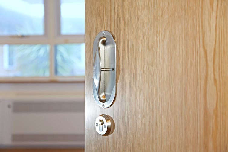 A wooden door partially open.