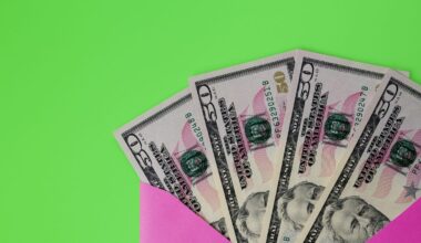 $50 cash bills peeking out of pink envelope