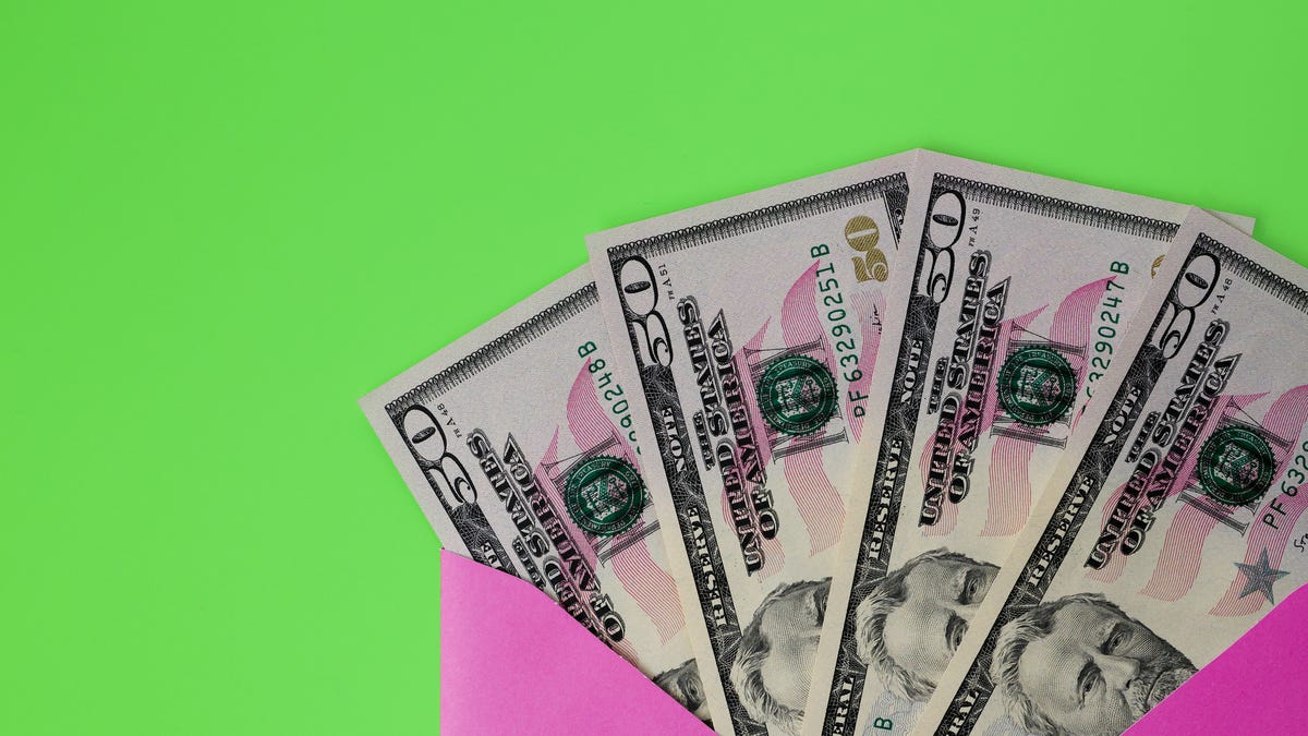 $50 cash bills peeking out of pink envelope