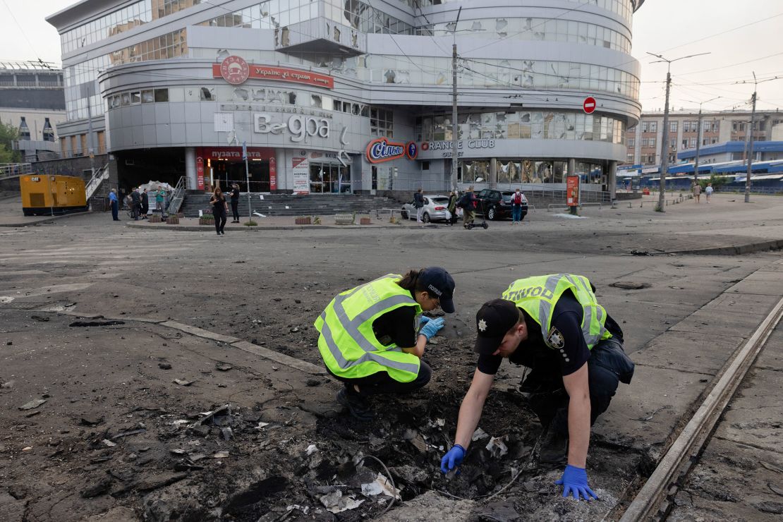 Police officers examine debris on a street in Kyiv.