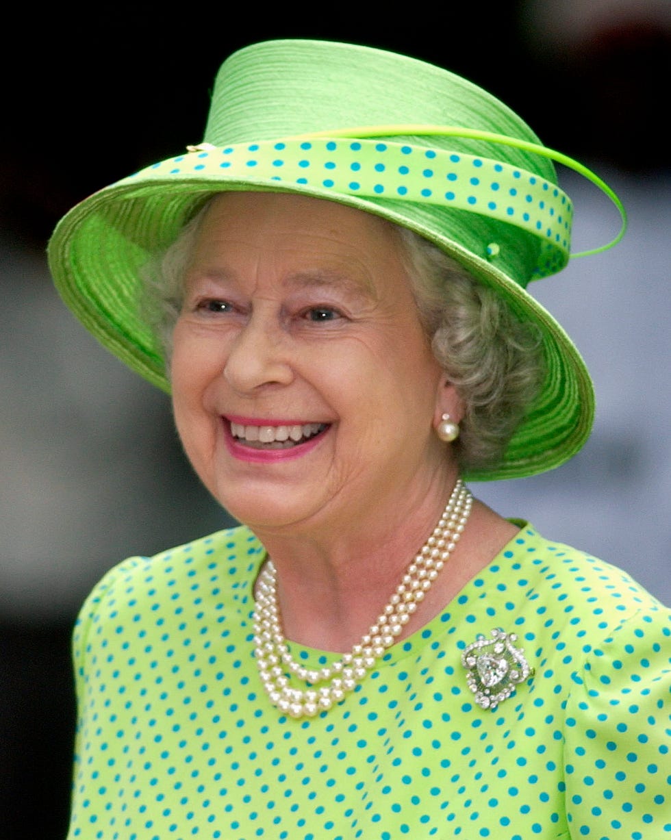 montego bay, jamaica february 20: queen elizabeth ll laughing whilst attending the governor generals garden fair at the half moon hotel to see jamaican produce and listen to jamaican music. the queen is wearing a lime green dress with blue polka dots and a geen hat trimmed with material to match the dress. she has chosen to wear a pearl necklace, pearl earrings and a diamond brooch with this outfit. she is wearing a hat by philip somerville. (photo by tim graham photo library via getty images)