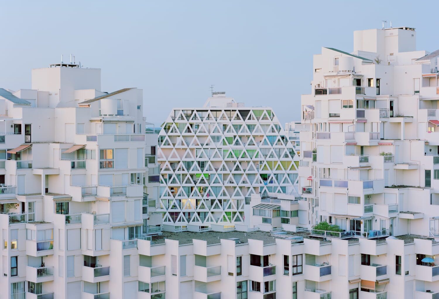 a modernist resort apartment complex in all-white against a blue sky