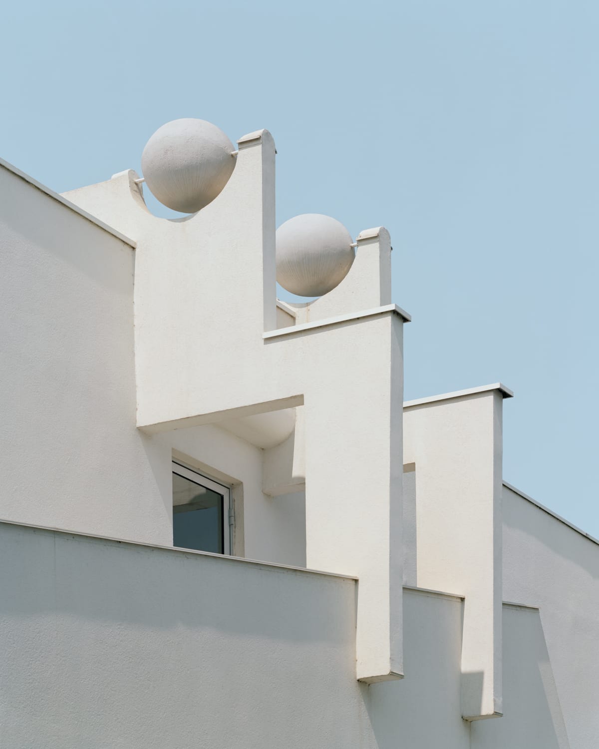 a detail of modernist architecture against a blue sky
