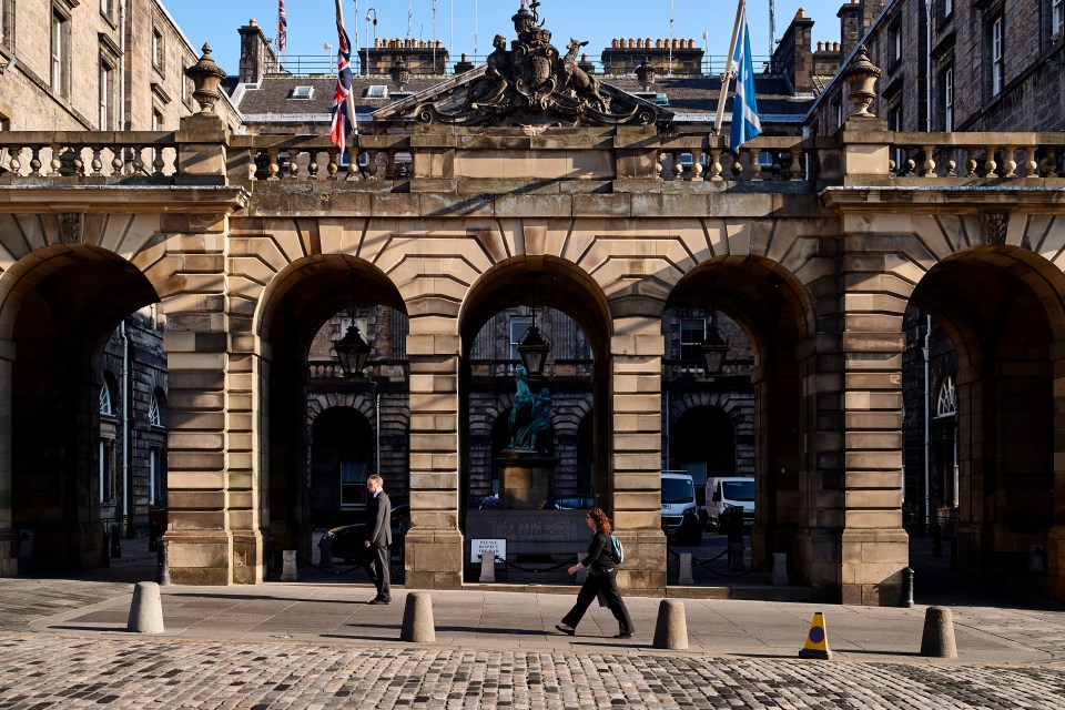 Edinburgh City Chambers on the Royal Mile with two people walking in front.