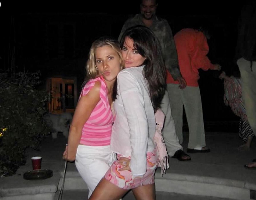 Two women posing for a photo at night.
