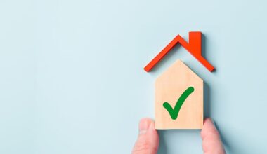 A basic house shape with a green tick painted on it set against a blue background