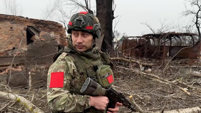 Russian army soldier walks along a ruined street of Malaya Loknya settlement