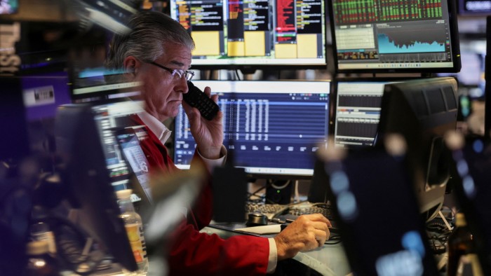 A trader works on the floor at the New York Stock Exchange in New York City
