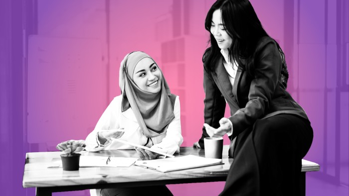 Two women chatting and smiling in the office