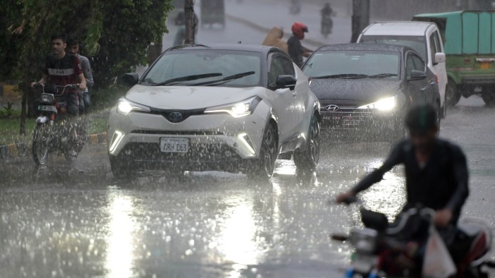 Vehicles try to drive through heavy rainfall