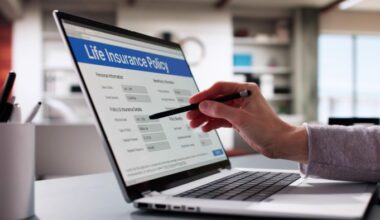 A person filling out a life insurance policy application form on a laptop