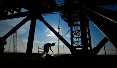 A worker is silhouetted at the construction site of the Olmeca oil refinery
