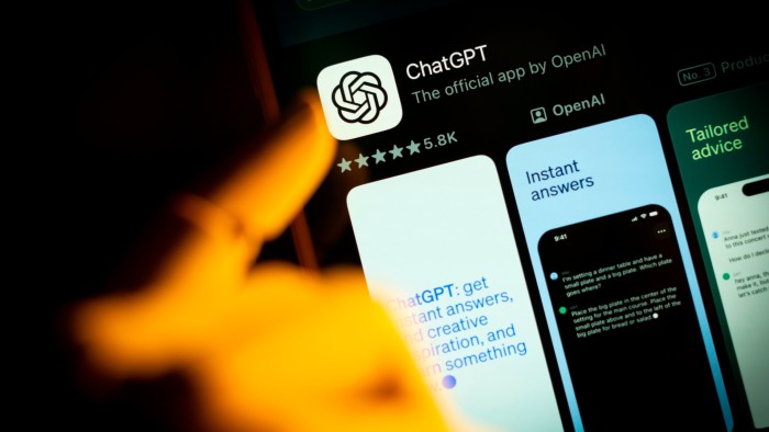 An artificial hand is seen pointing a finger onto a mobile phone screen displaying the Apple App Store with the Chat GPT app