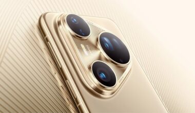 Close-up image of a gold smartphone's rear camera module, featuring three large camera lenses and a flash, set against a matching gold textured background.