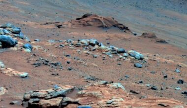 Image of a mix of rocks and dust, with the dust having a strong reddish tint.