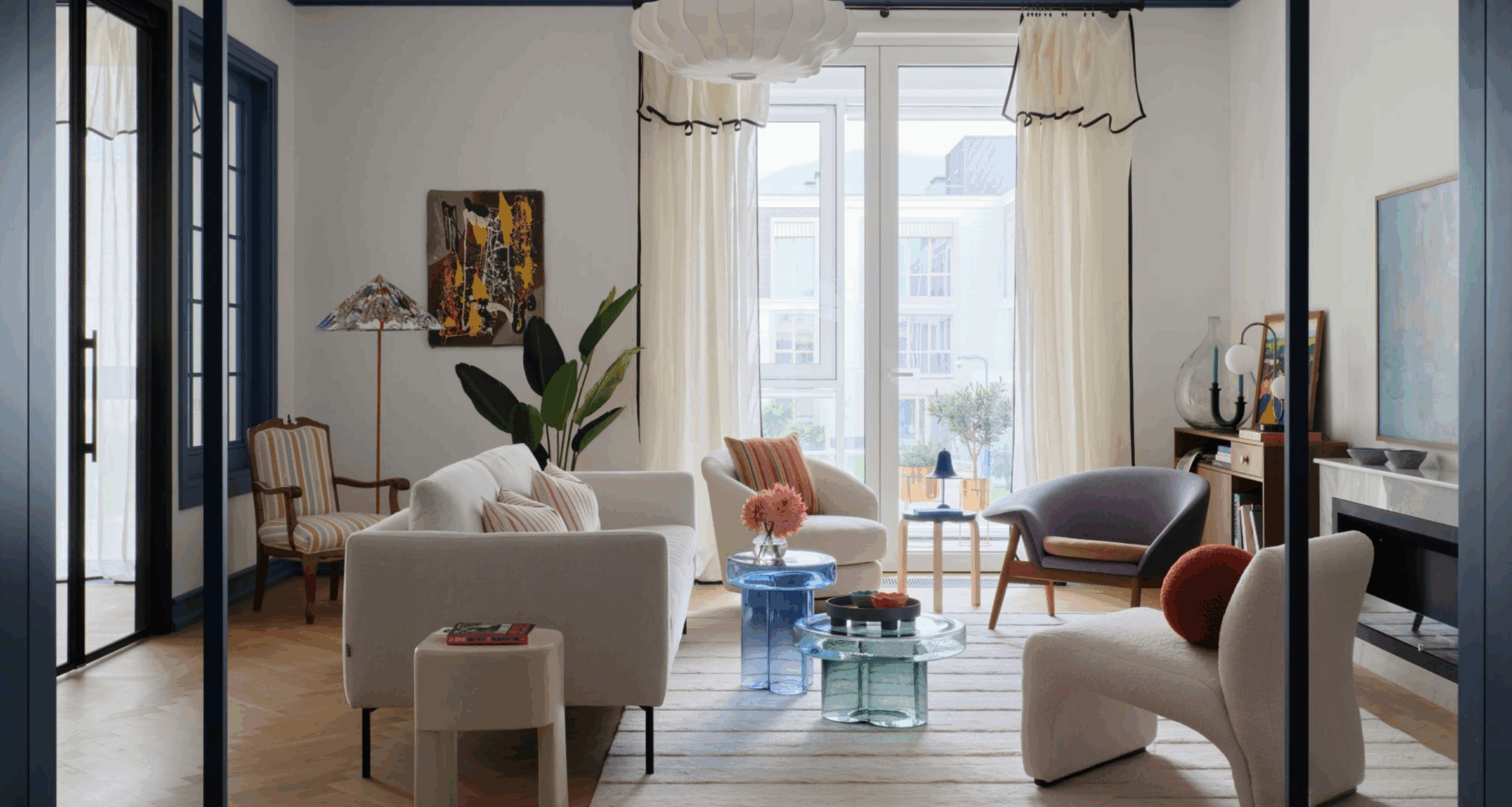 Beautiful open plan living room through an arched door way with floor to ceiling windows and contemporary furniture