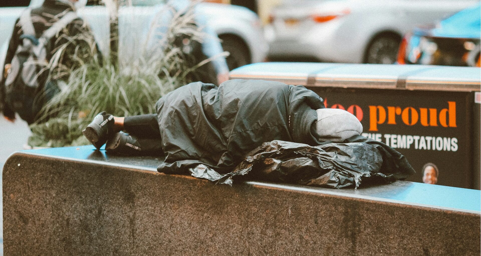 a homeless person lying on a bench