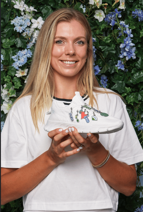 Katie Boulter holding a tennis shoe decorated in limited edition Amex charms, made for Wimbledon 2025 
