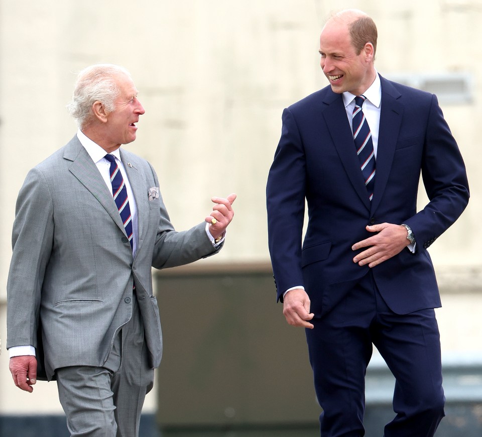 a man in a suit talks to another man in a suit