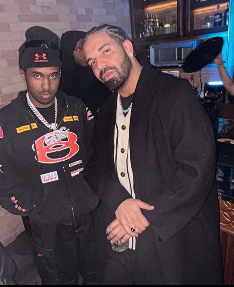 Drake and another man posing for a photo.