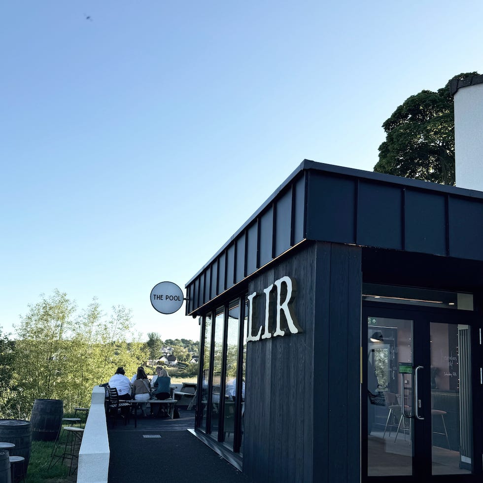 exterior view of a restaurant named lir featuring outdoor seating and a sign indicating a pool area
