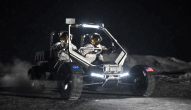 In an artist's concept, two astronauts ride on a lunar terrain vehicle on the surface of the Moon