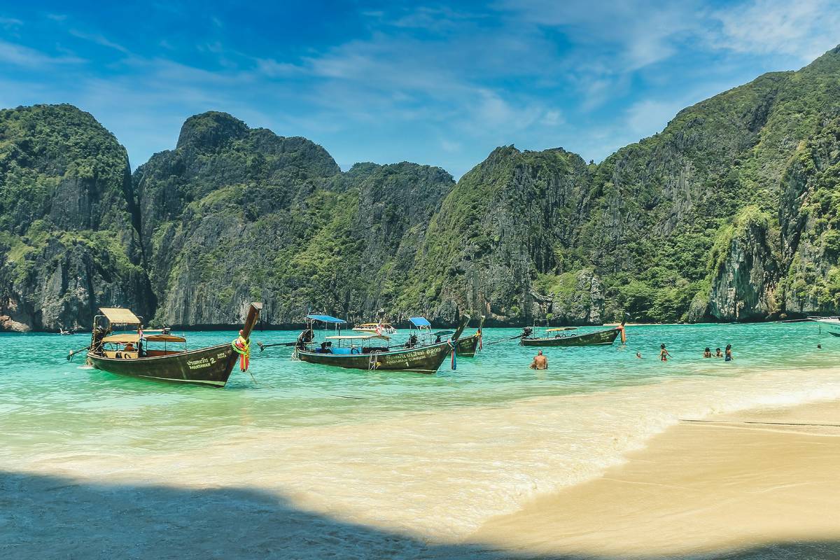 koh phi phi island beach in thailand with boats and clear blue ocean