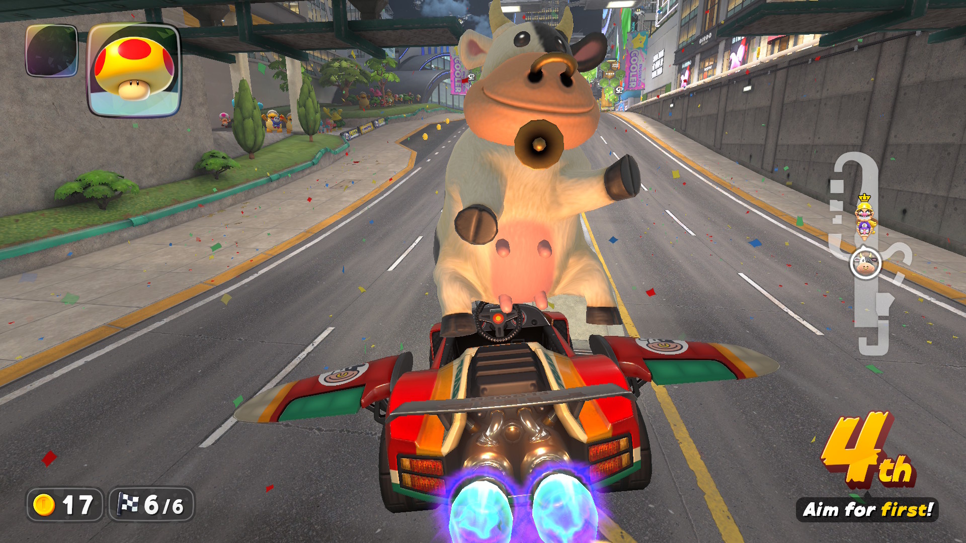 The cow in Mario Kart World, posing on her hind legs while standing up in a car that’s flying like a plane