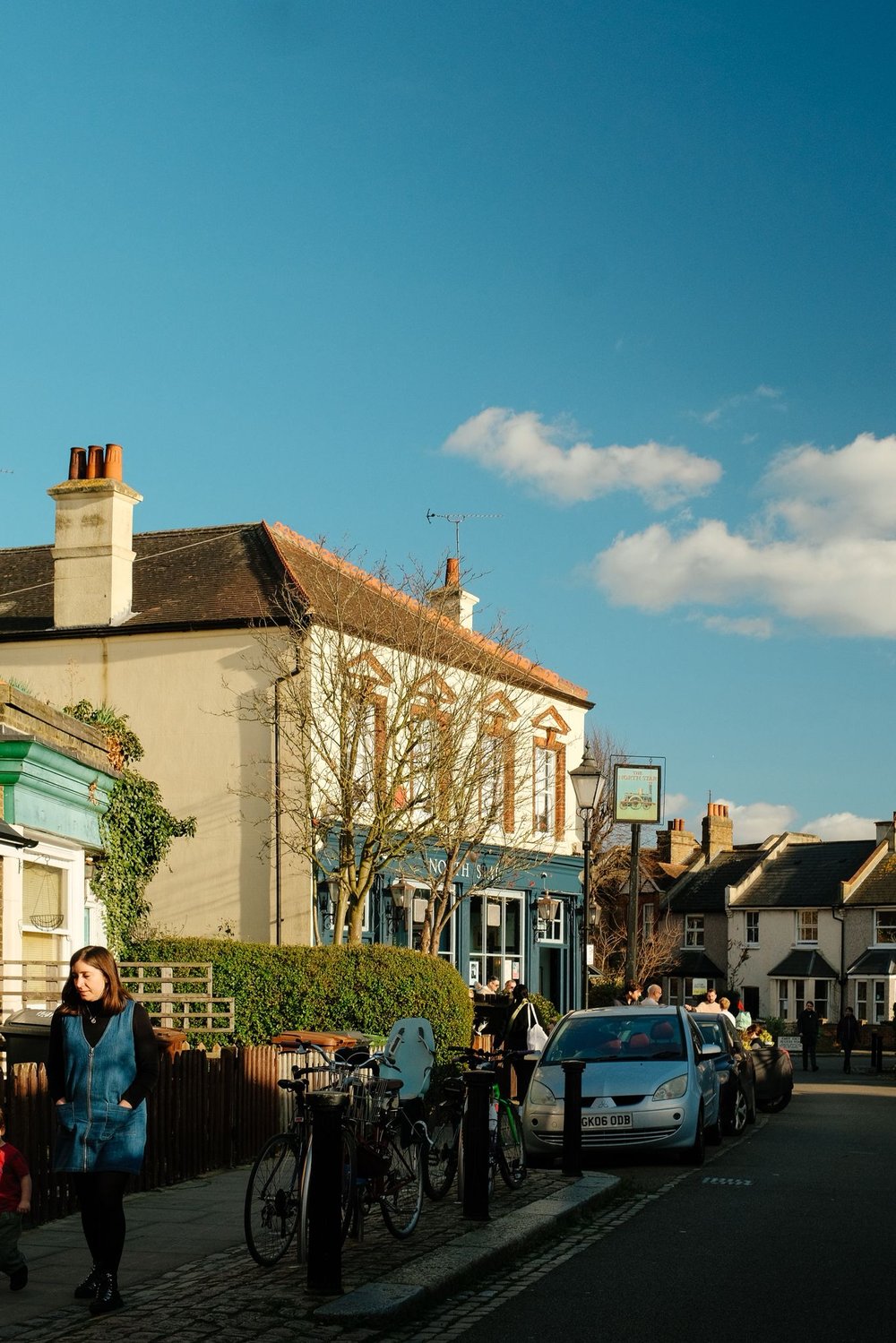 the exterior of the north star pub as seen from down the road, with the sun shining off the pub