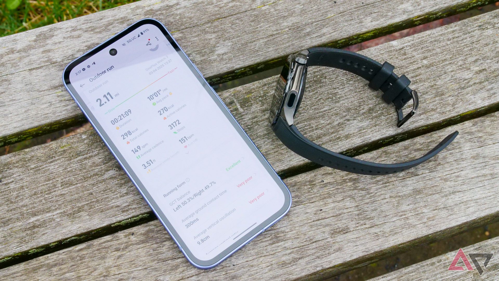 The OnePlus Watch 3 next to a Pixel 9a on a park bench with metrics displayed on the Pixel.