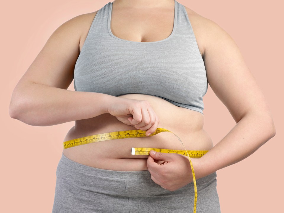 Woman measuring her waist.