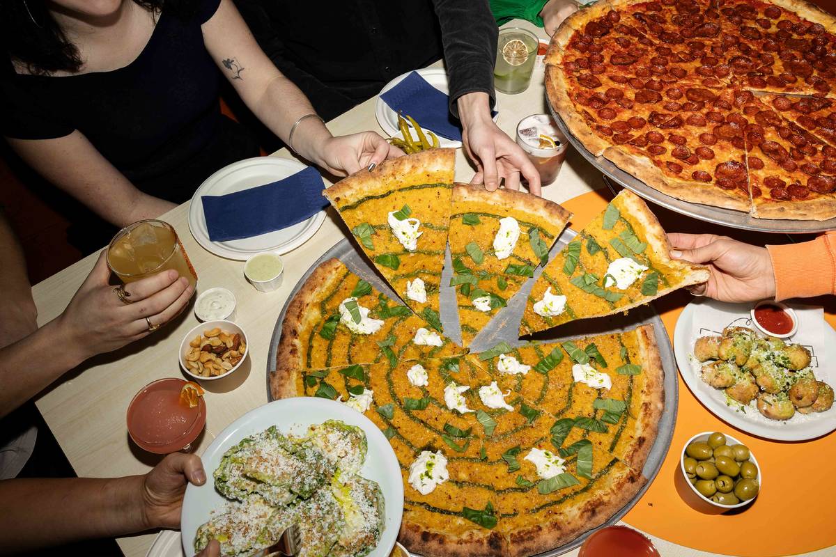 people taking 22 inch slices of pizza at nell's