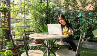 Woman using laptop on table in green garden