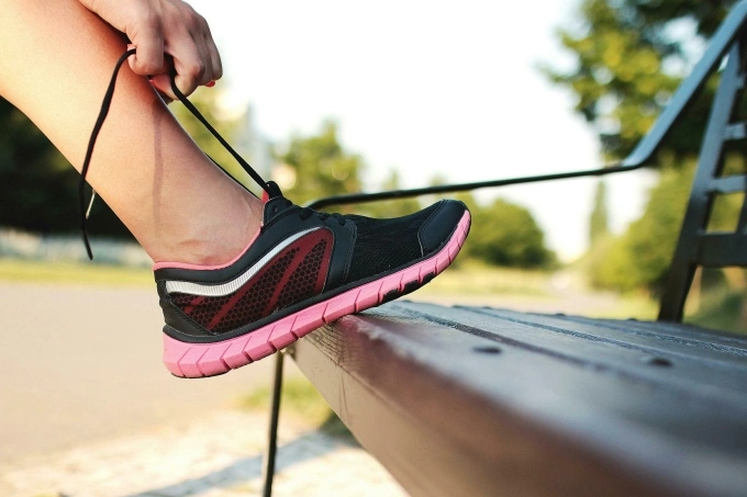 A person tying their shoelaces. Illustrative photo by Pexels