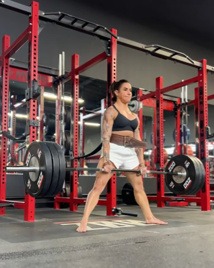 Powerlifter Stefi Cohen lifting heavy weights in a gym setting, showcasing strength and fitness training.