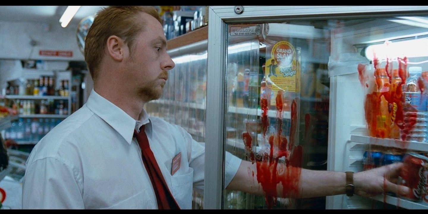 Shaun (Simon Pegg) reaches into a convenience store cooler, oblivious of bloody handprints on the glass in Shaun of the Dead (2004).