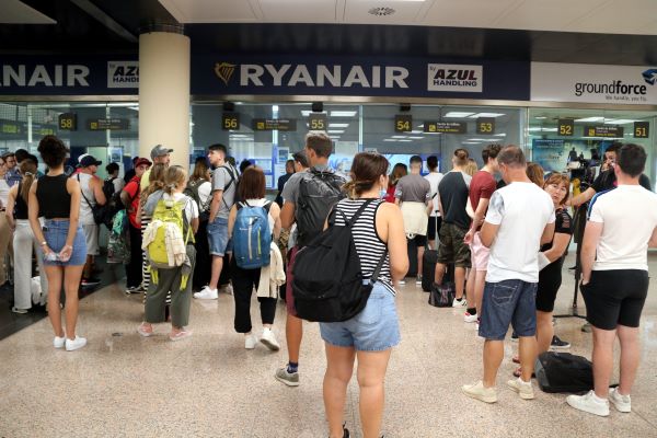 Passengers who have had flights canceled queue at the Ryanair help desk in Barcelona airport