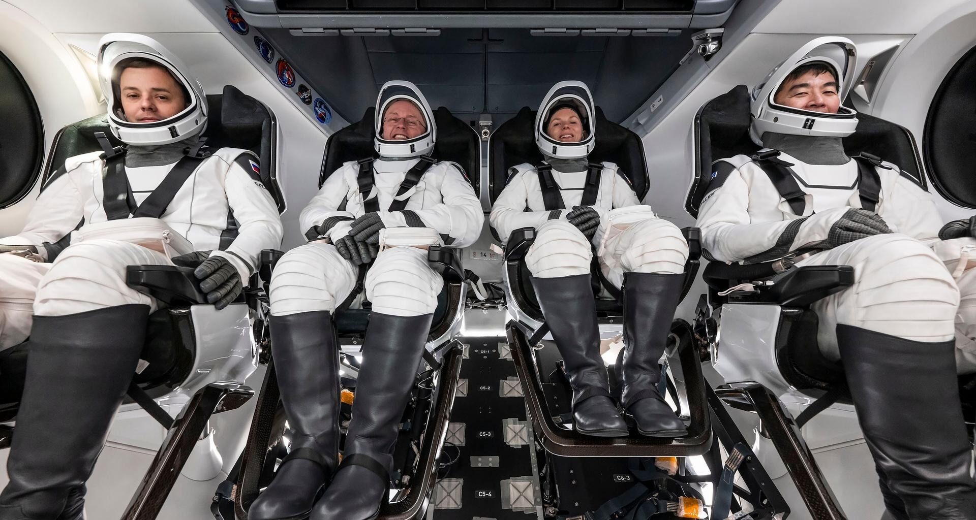 astronauts in white spacesuits pose for portraits