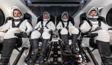 astronauts in white spacesuits pose for portraits